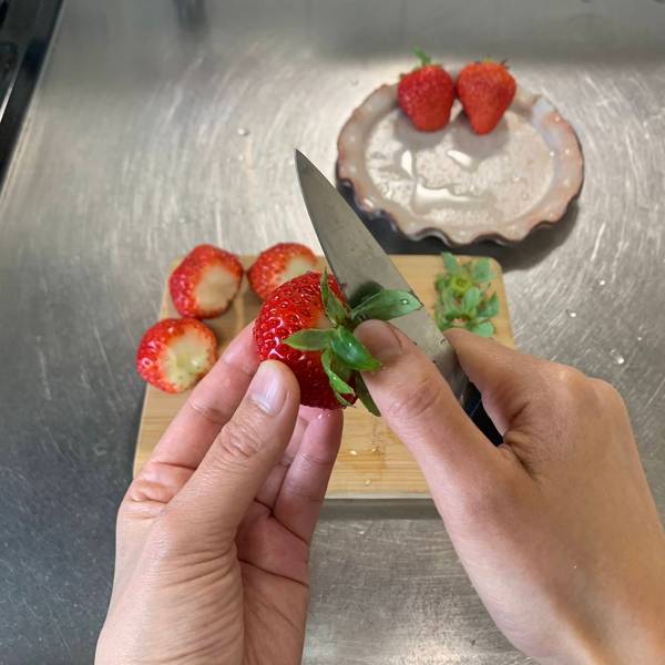Cutting the stems off of the strawberries
