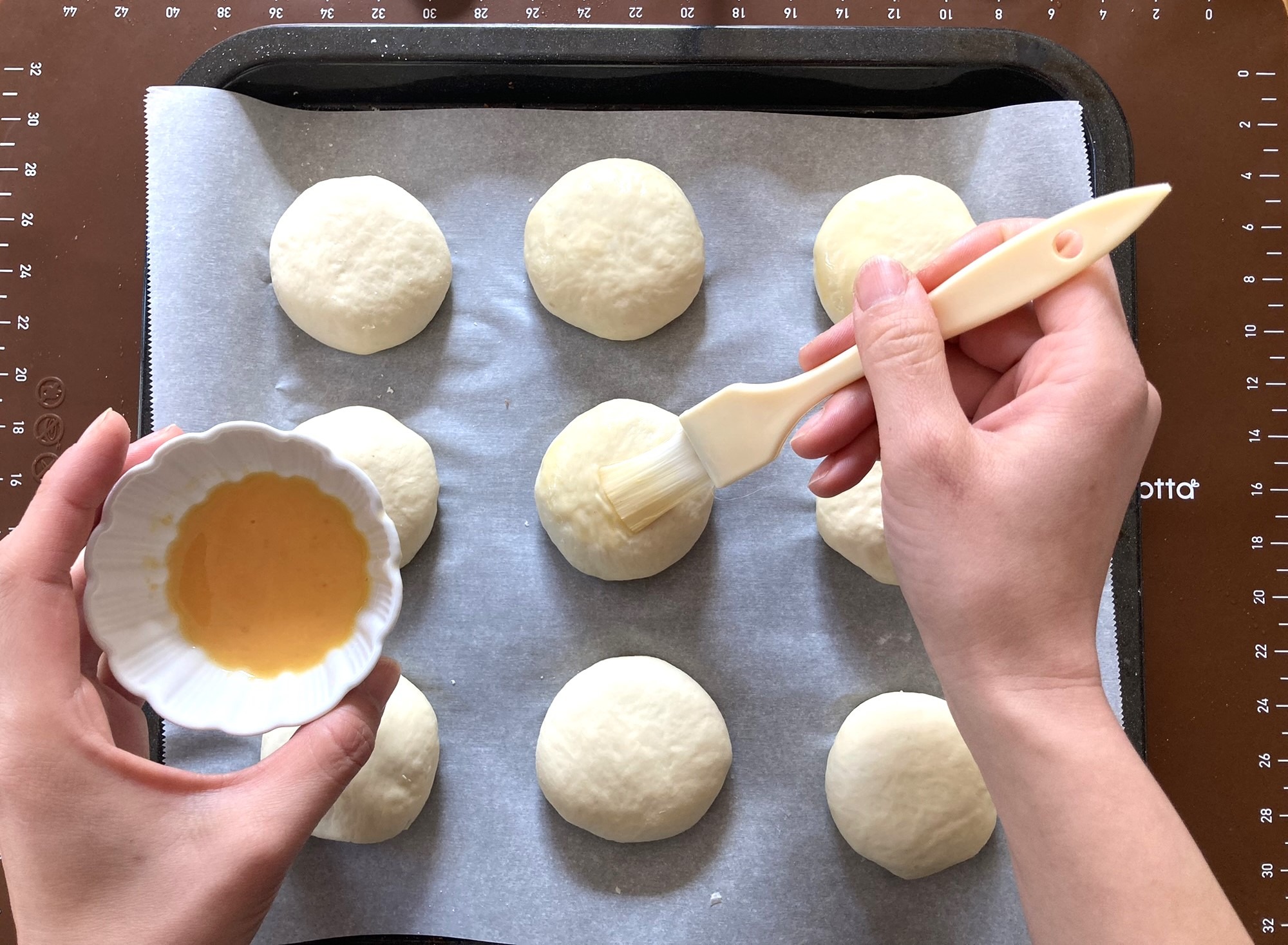 Adding egg wash to the anpan