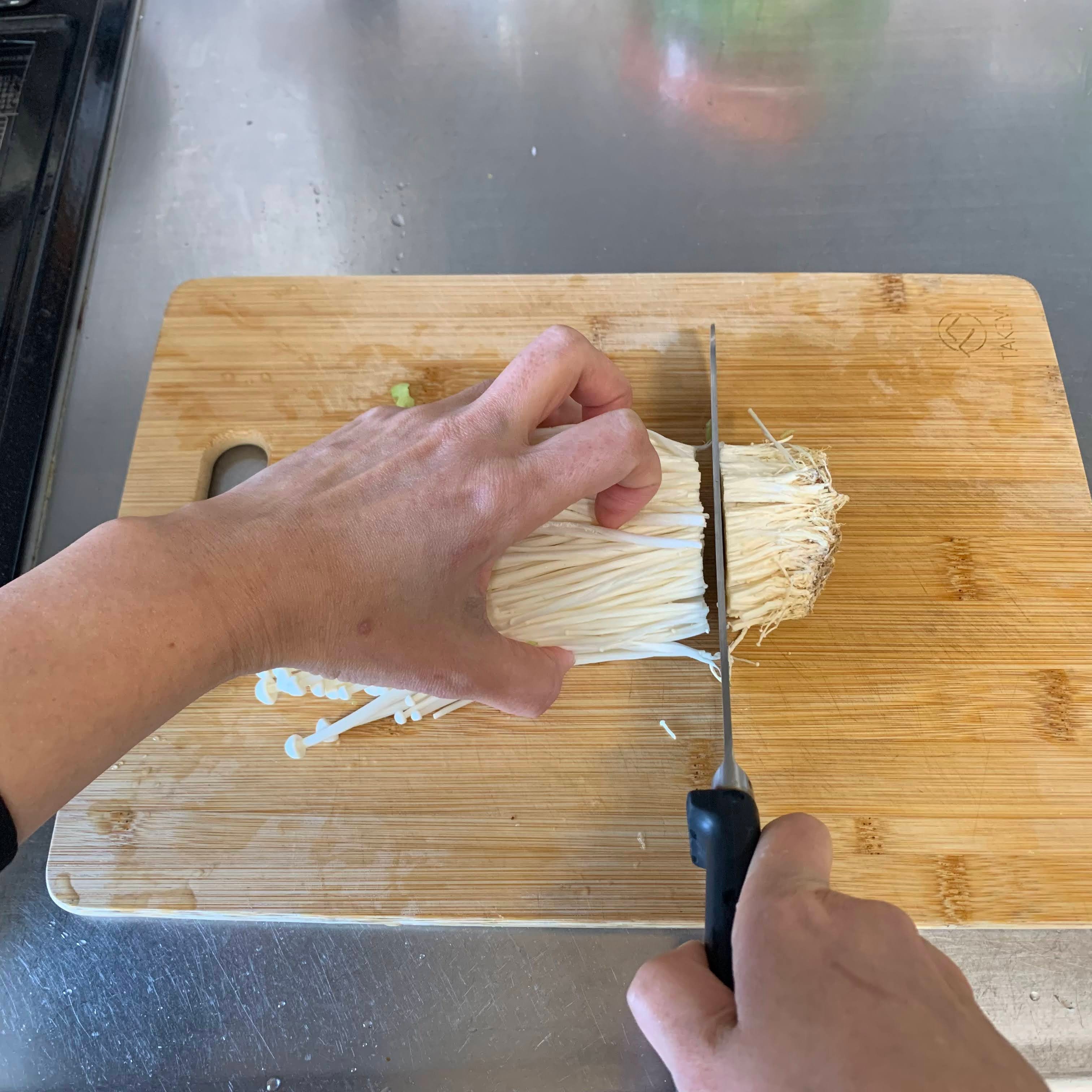 Chopping the bottom part of the enoki mushrooms