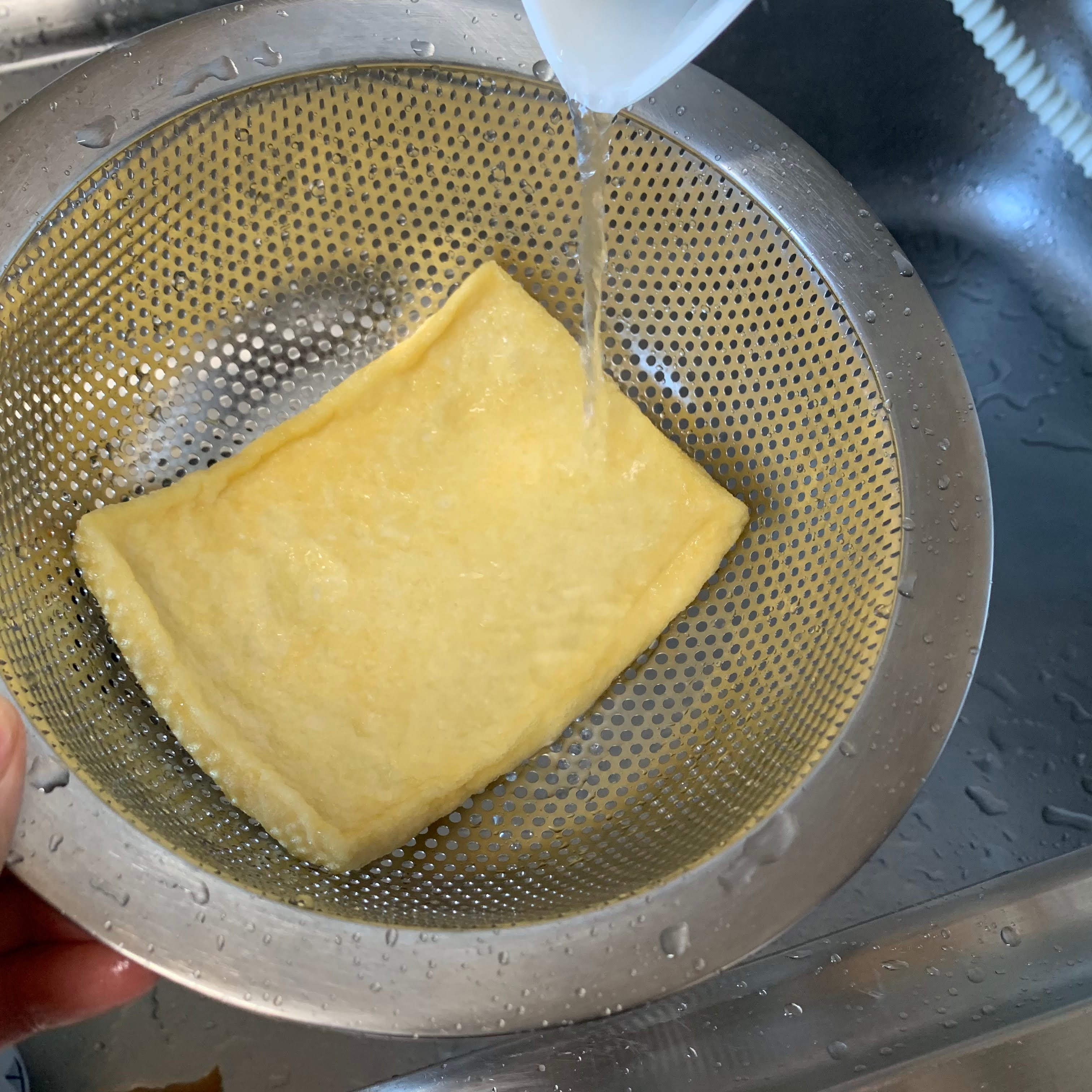 Pouring boiling water over the fried tofu