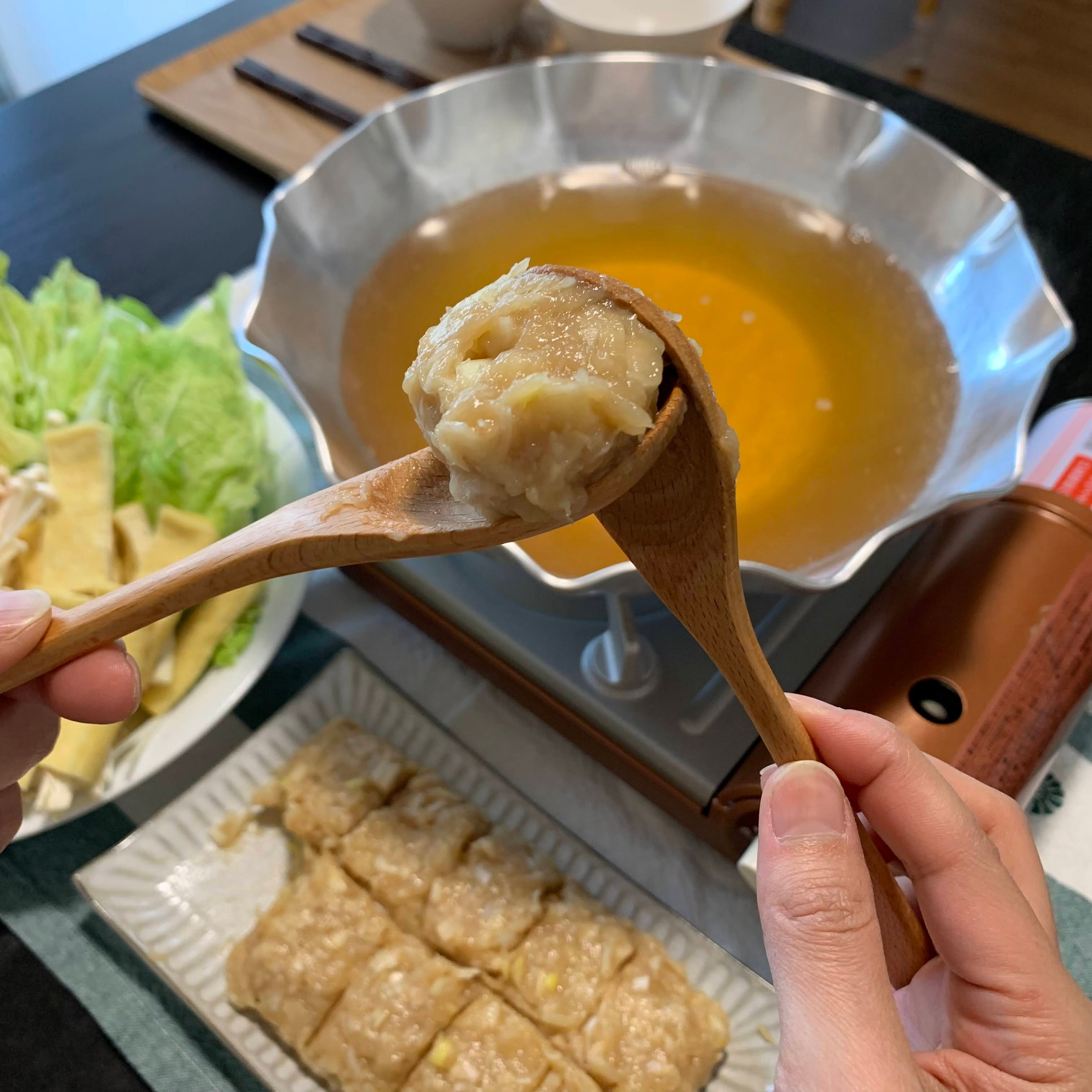 Using two spoons to scoop the chicken meatballs