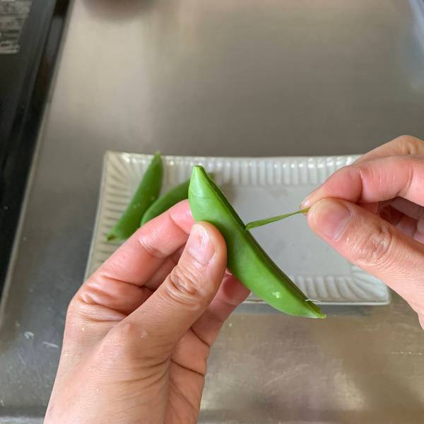 Removing the strings from the snap peas
