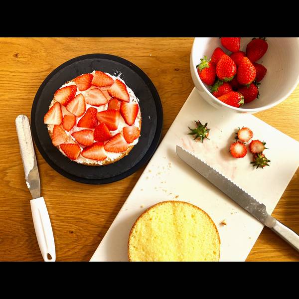 Adding sliced strawberries in the middle of the cake