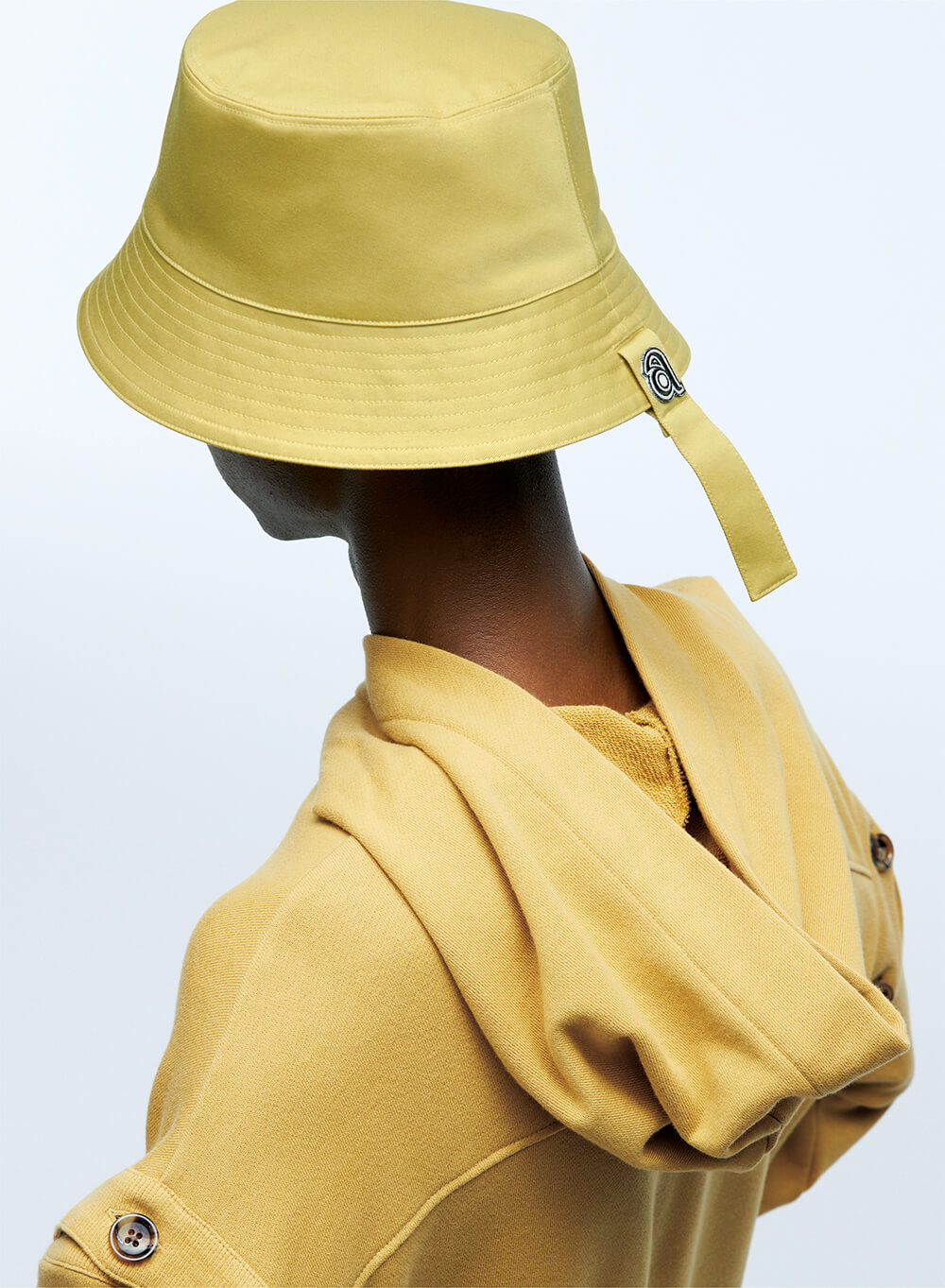 back view of a model in a bucket hat and hooded sweatshirt
