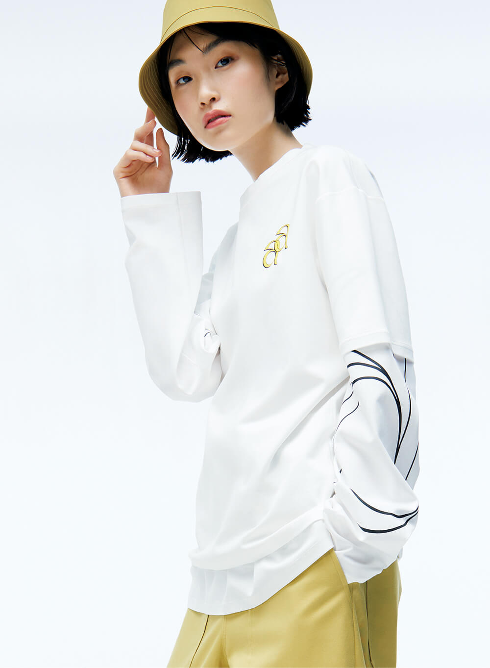 close up of model in unisex long sleeve tee shirt and bucket hat