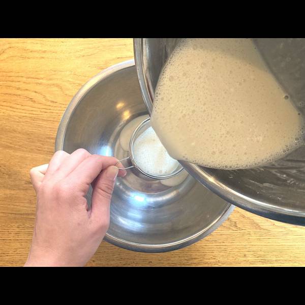 Straining the mochi dough using a fine sieve 