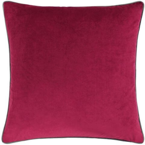 A front view of a red velvet cushion in a cranberry shade with a brown piped border.
