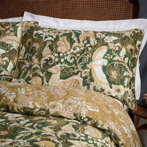 An emerald green duvet cover set with an intricate design of British woodland animals and florals, complete with a coordinating tonal reverse.