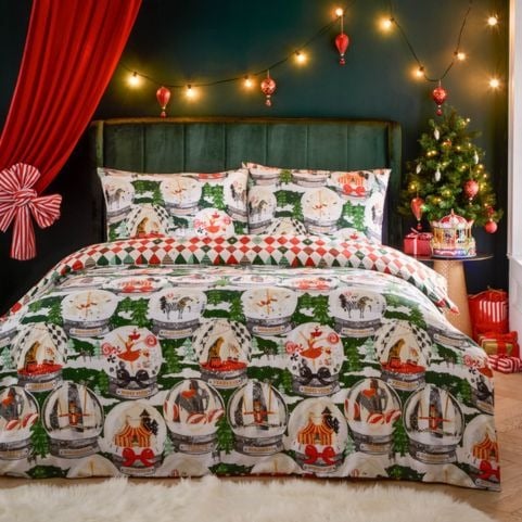 A green Christmas bedding set with a printed design of snow globes and classic seasonal motifs.