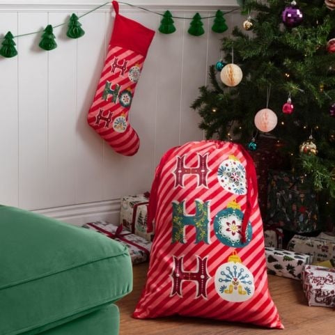 A matching set of velvet Christmas sacks and stockings with a printed design that reads 'Ho Ho Ho'.