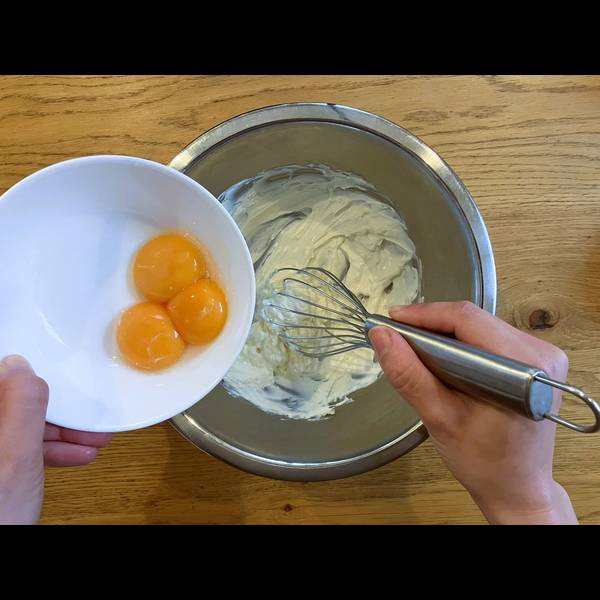 Adding the egg yolks to the cream cheese mixture