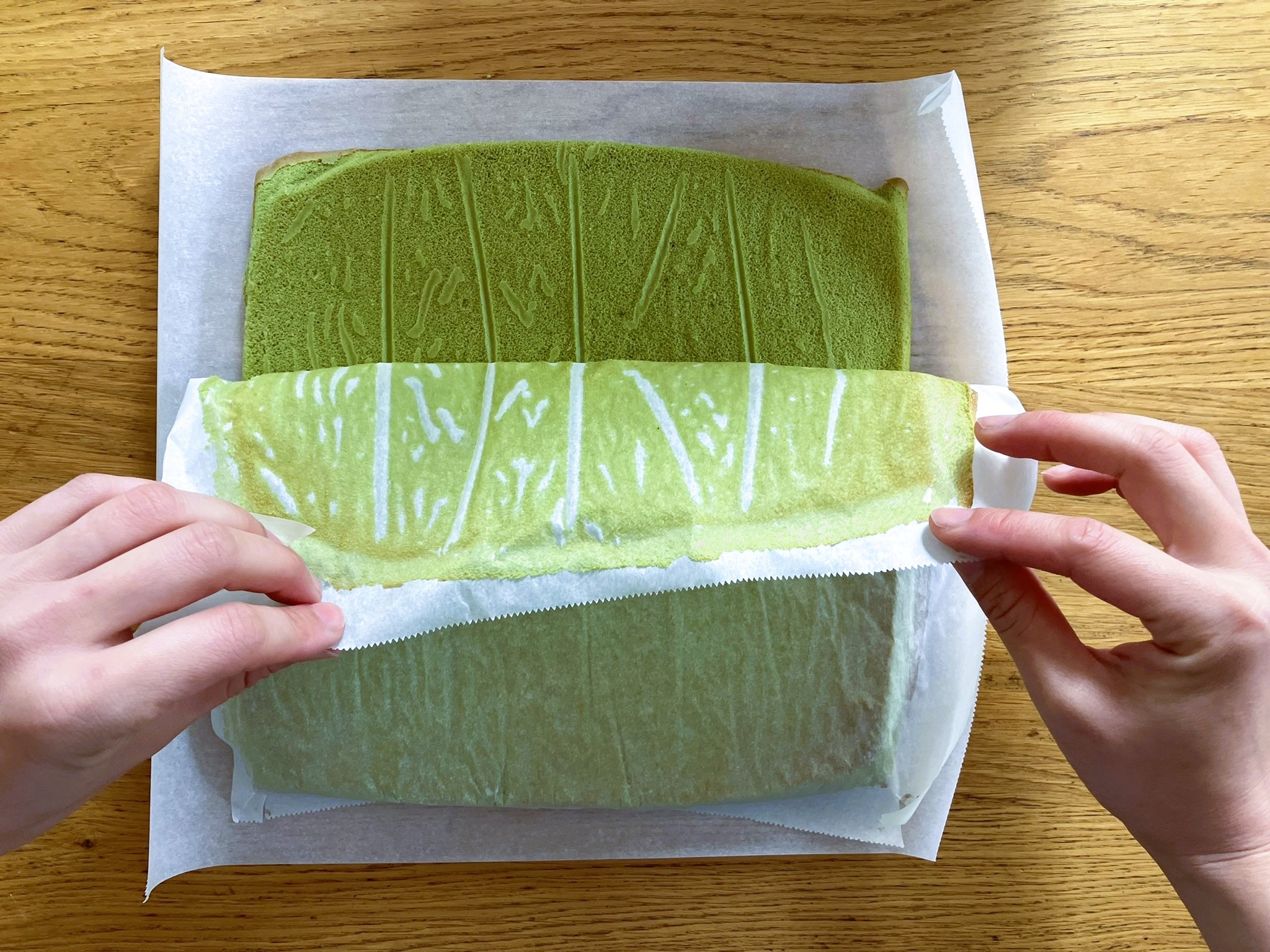Flipping the cake onto another piece of parchment paper 