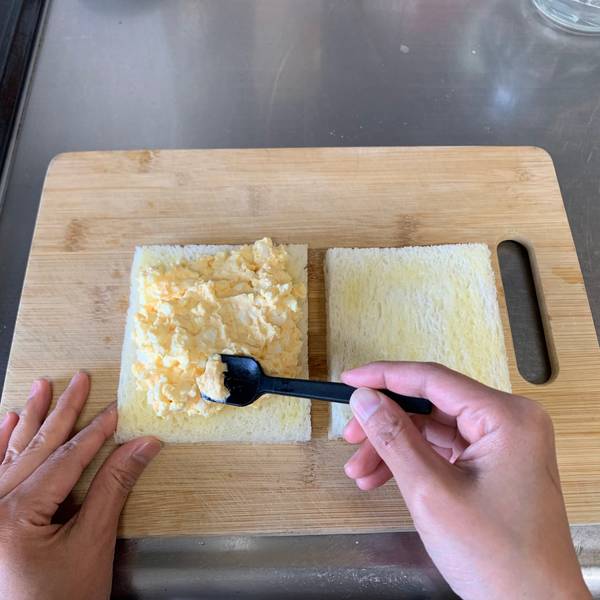 Adding the egg salad to the bread 