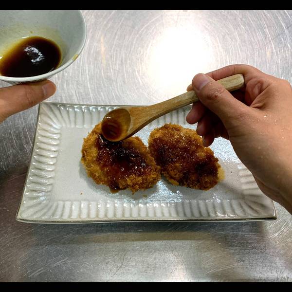 Adding tonkatsu sauce to each piece of tonkatsu