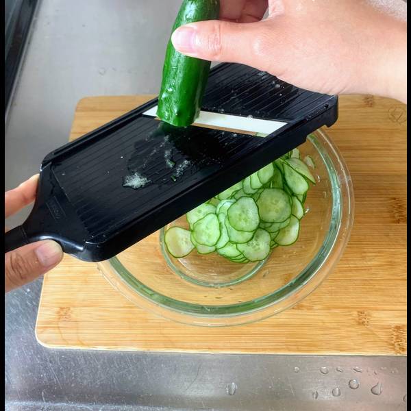 Slicing the cucumber with a mandolin