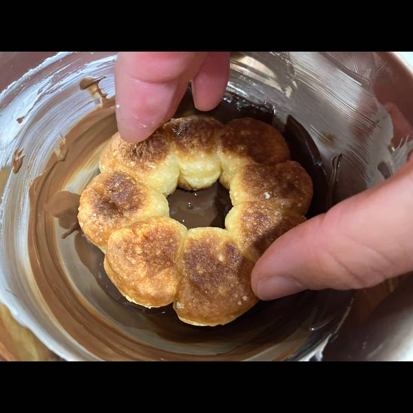 Dipping the donut in melted chocolate