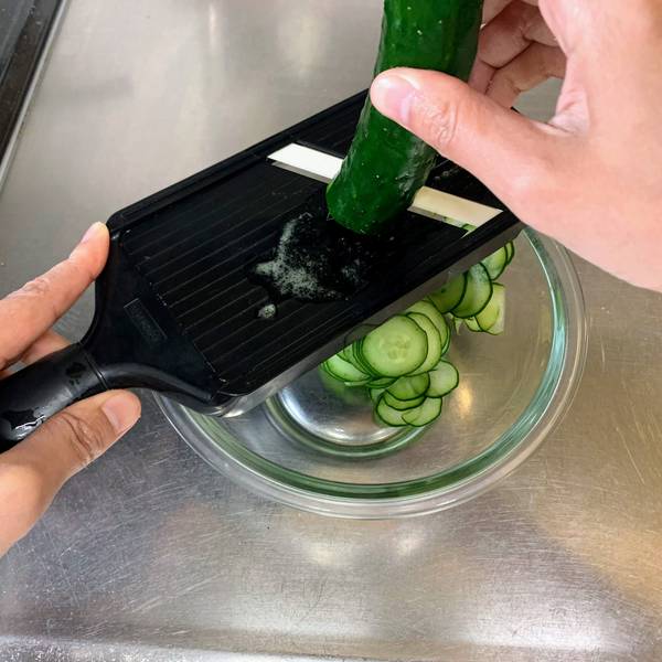 Slicing the cucumbers with a mandolin