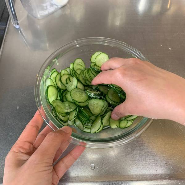 Mixing salt into the cucumbers