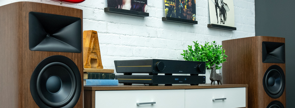 ARCAM Radia Series components on a table between two speakers