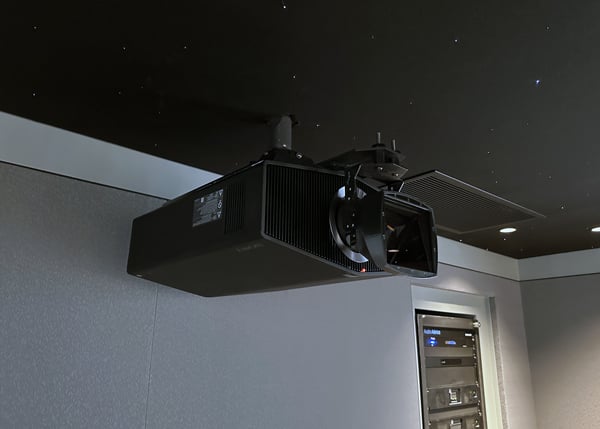 Home theater projector mounted on a ceiling with a Panamorph lens