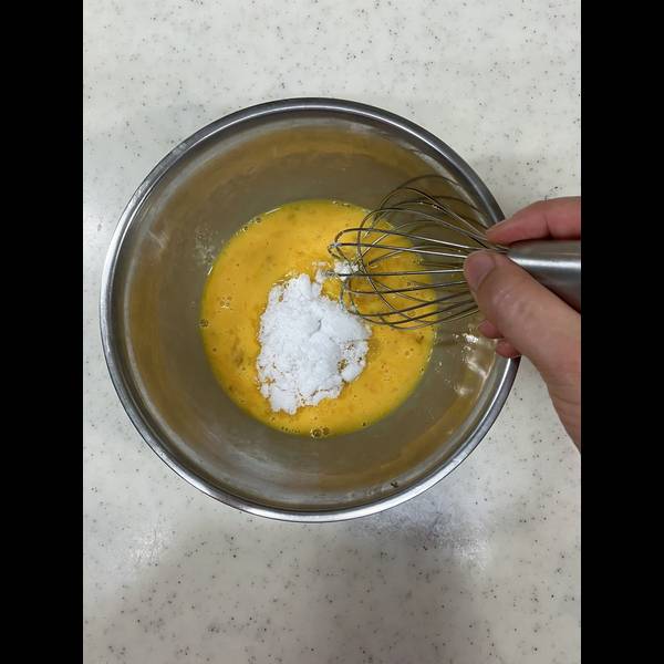 Adding the sugar to the eggs and mixing
