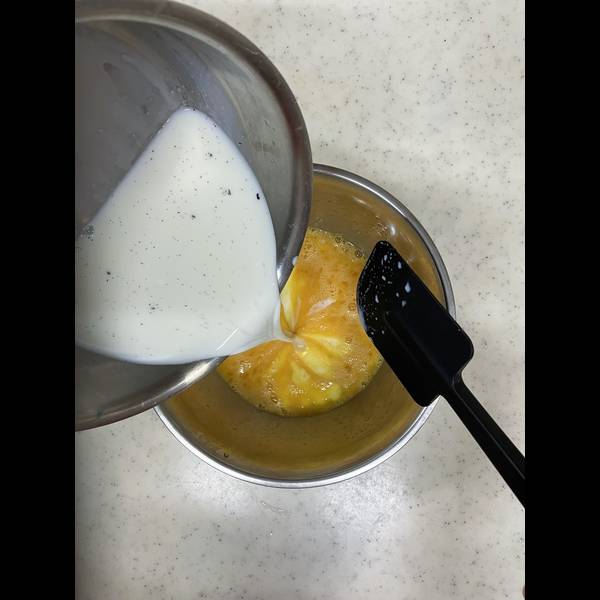 Mixing the warm milk with the eggs