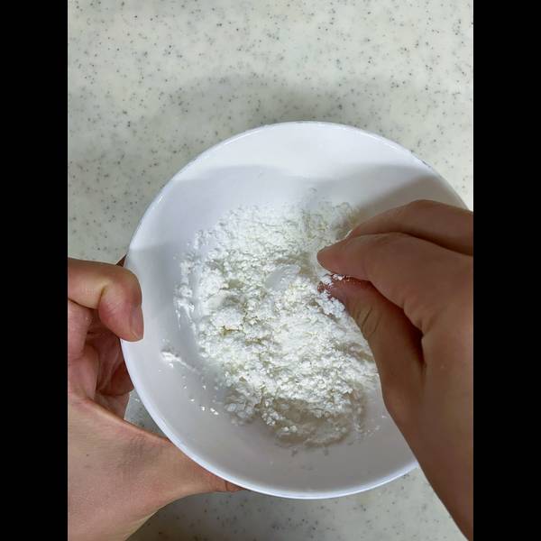 Shiratama dango flour and water in a bowl. Using hands to mix them together