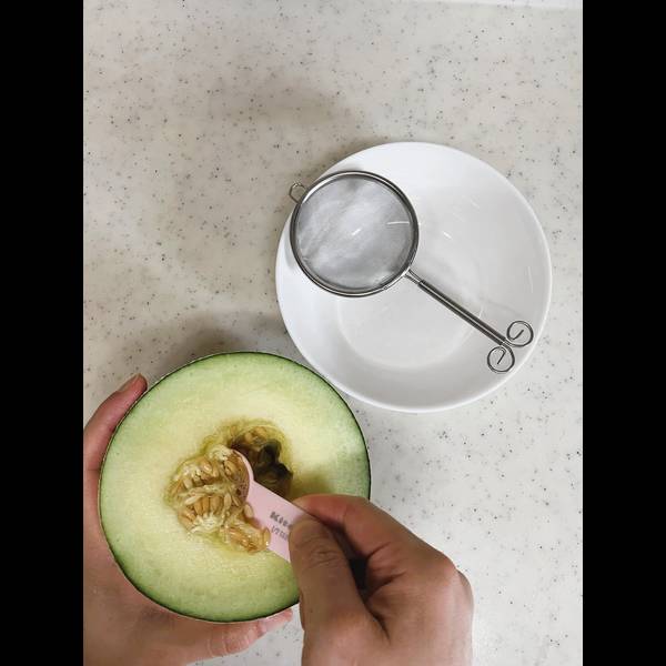 Scooping the melon seeds out of the melon