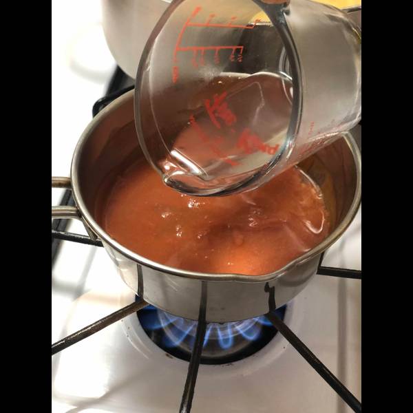 Adding the reserved pasta water to the ketchup sauce