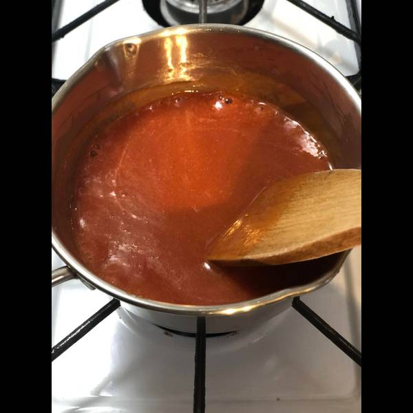 Simmering the sauce until it thickens