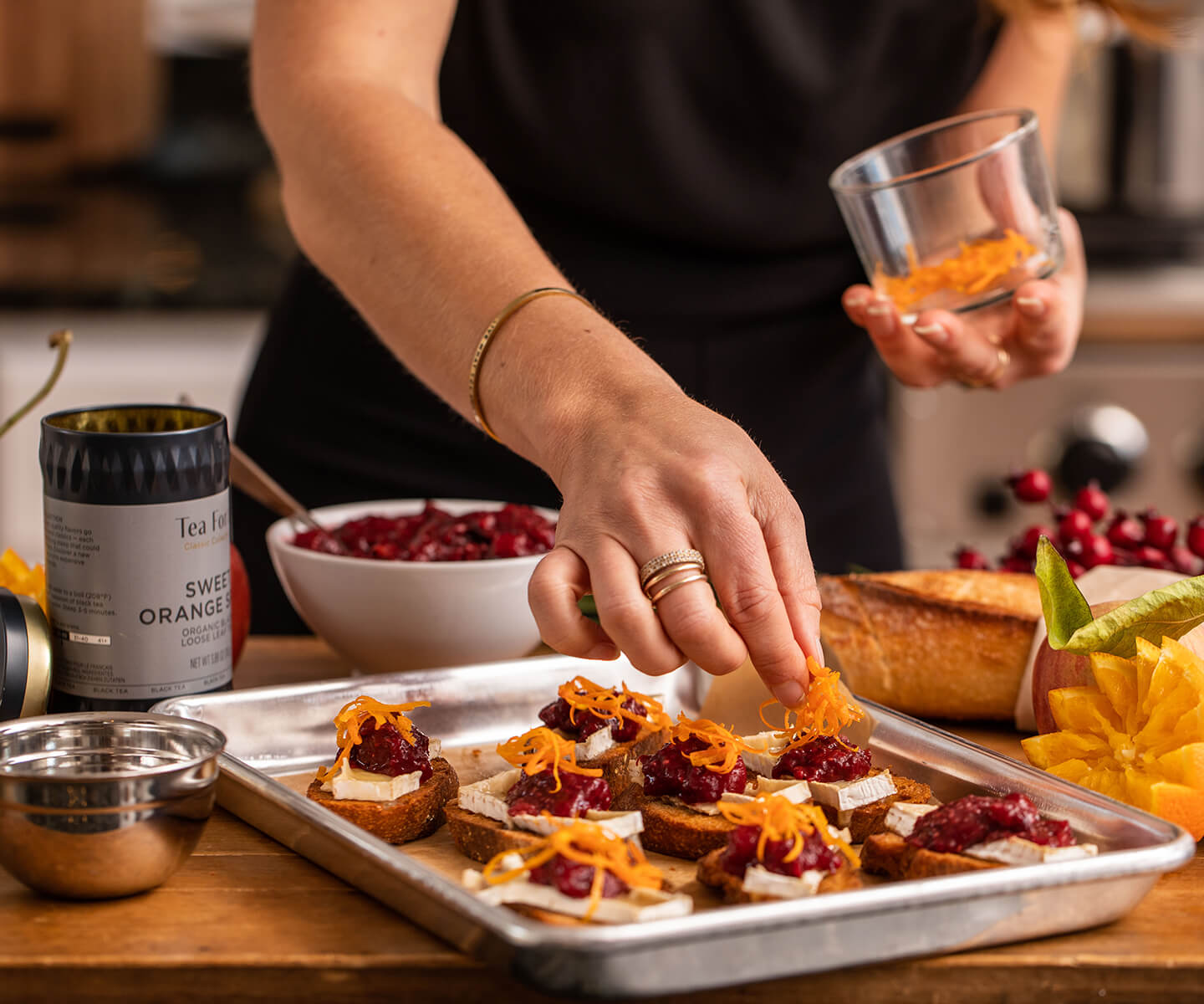 Making Sweet Orange Cranberry Brie Crostini in a kitchen