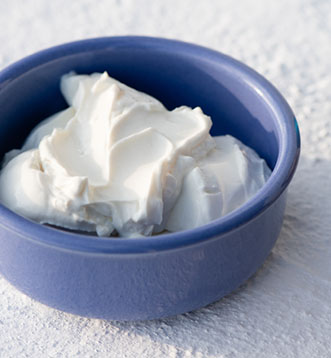 Blaue Keramikschüssel mit frisch zubereitetem griechischen Joghurt