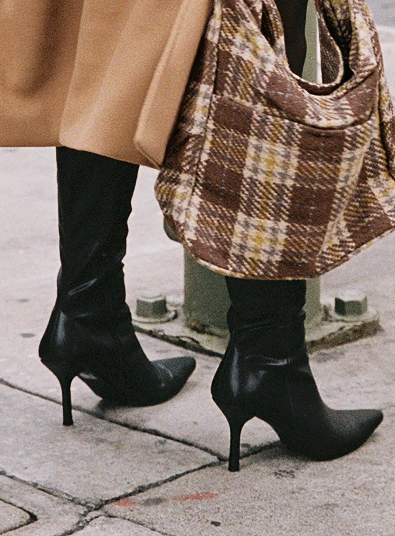 woman wearing black knee high boots styled with wide leg pants