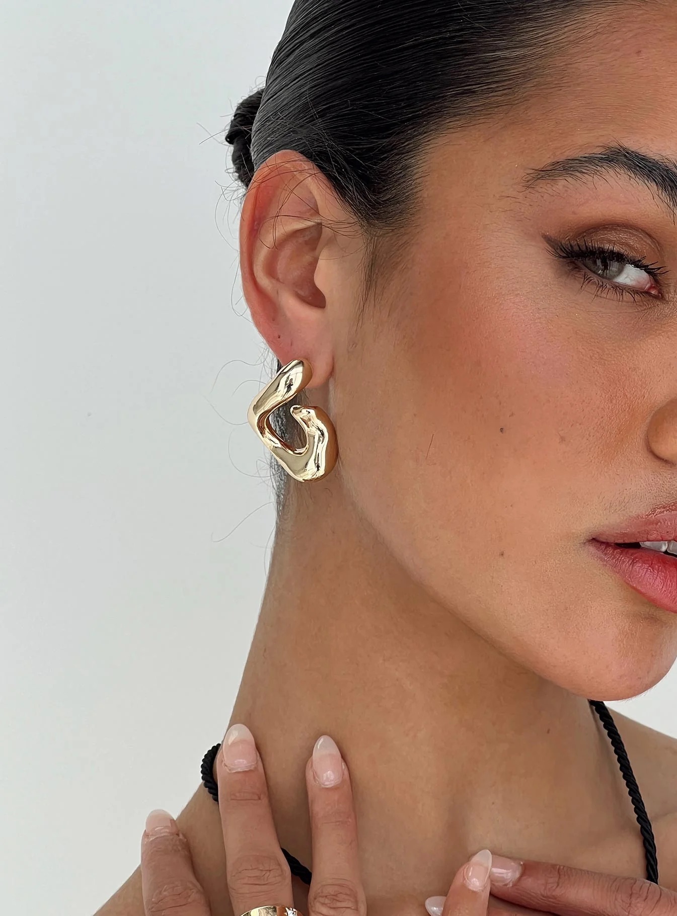 woman wearing gold earrings styled with wide leg pants