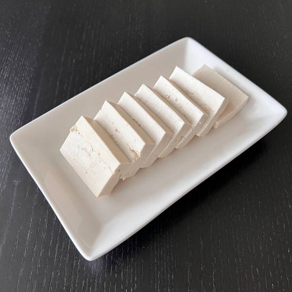 Drained tofu, sliced and ready to be stir-fried