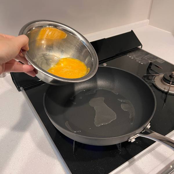Pouring beaten eggs into a hot pan