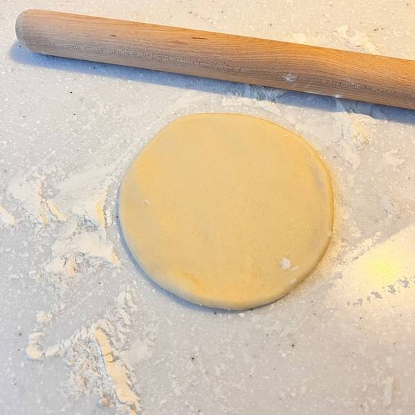 Rolling the dough out into a small round shape