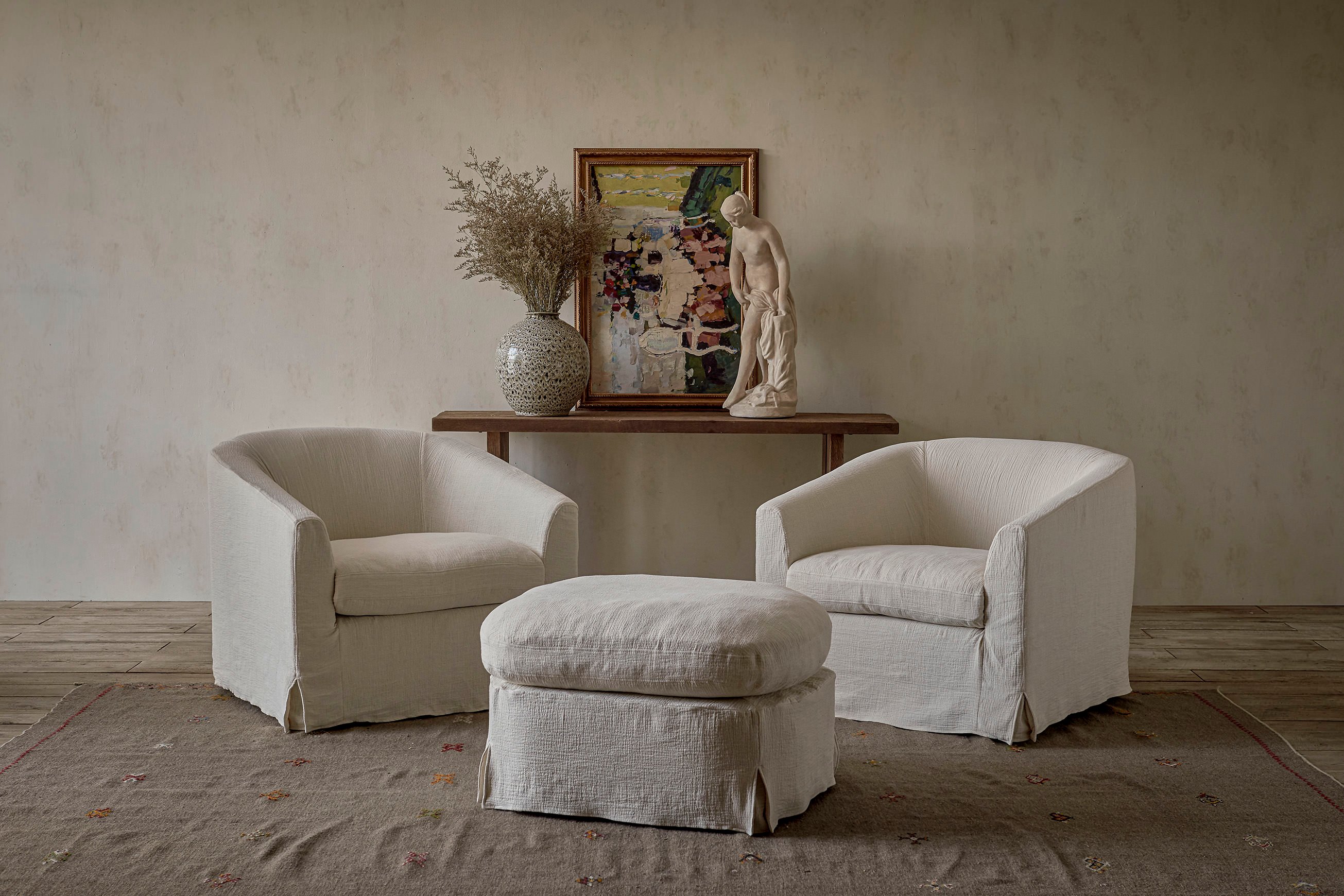 Two Ziki Chairs placed beside the Ziki Ottoman in Corn Silk, Washed Cotton Linen