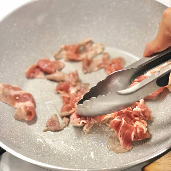 Stir-frying the pork in the pan