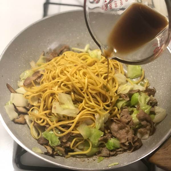 Adding the rest of the sauce into the yakisoba