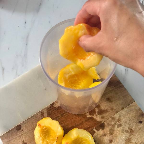 Adding peaches to a blending jug