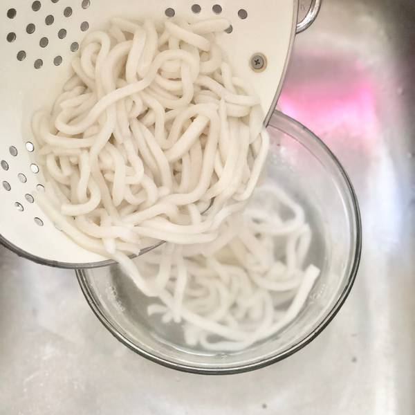 Adding the udon noodles to a bowl of cold water
