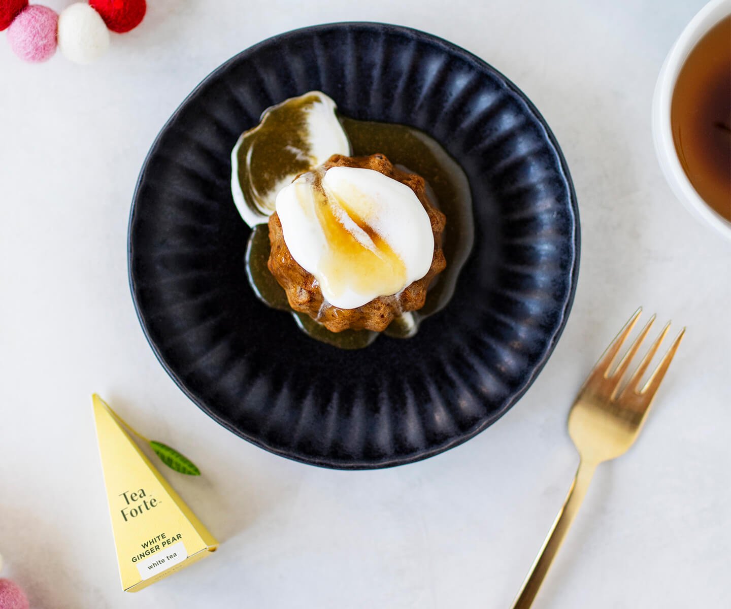 Spiced Ginger Sticky Pudding on a plate with fork and infuser