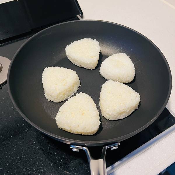 Adding the onigiri to a frying pan