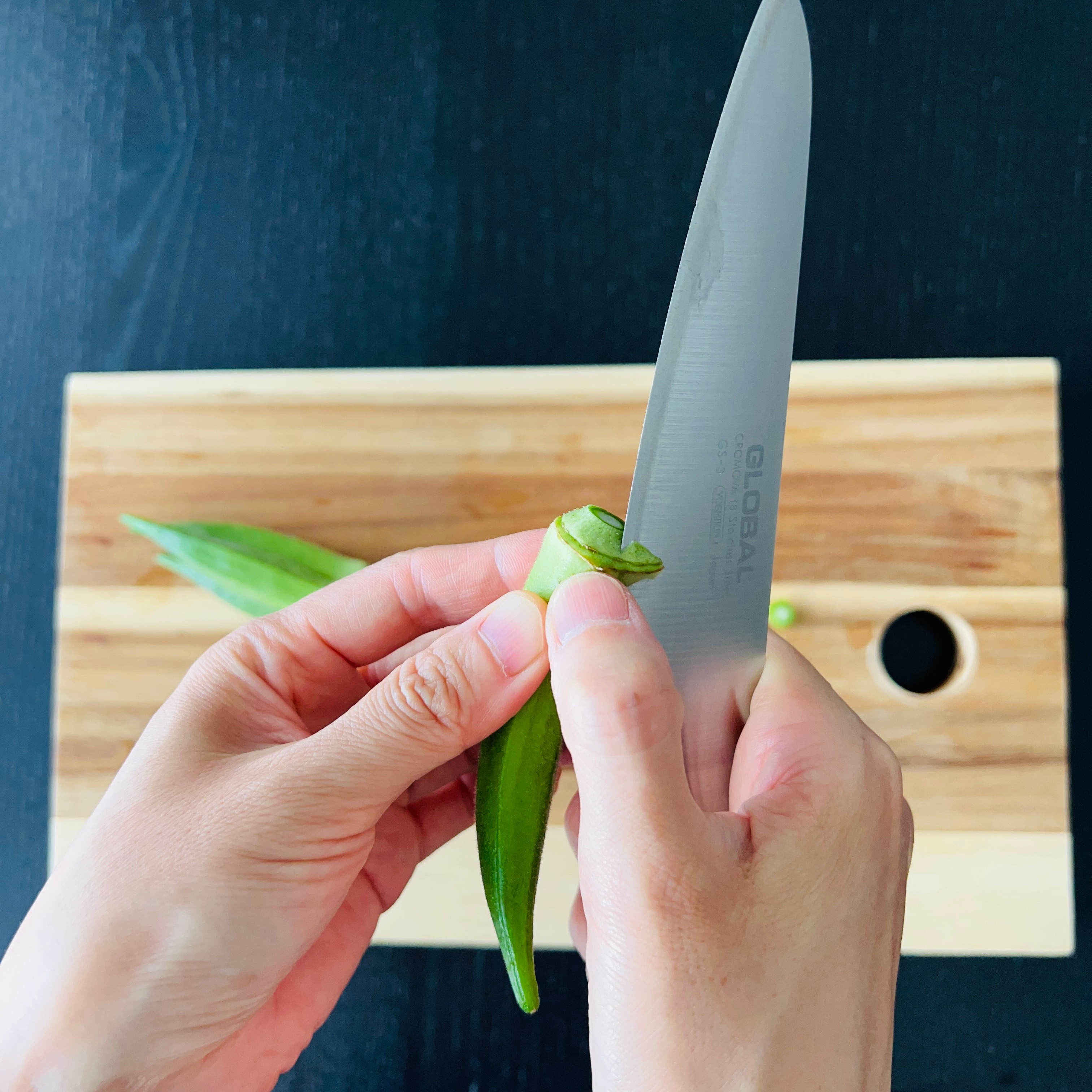 Peeling the tip of the okra off
