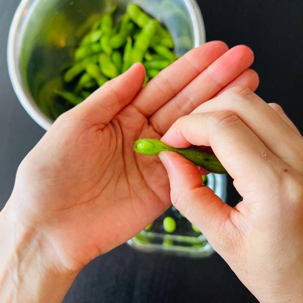 Removing edamame beans from their shells