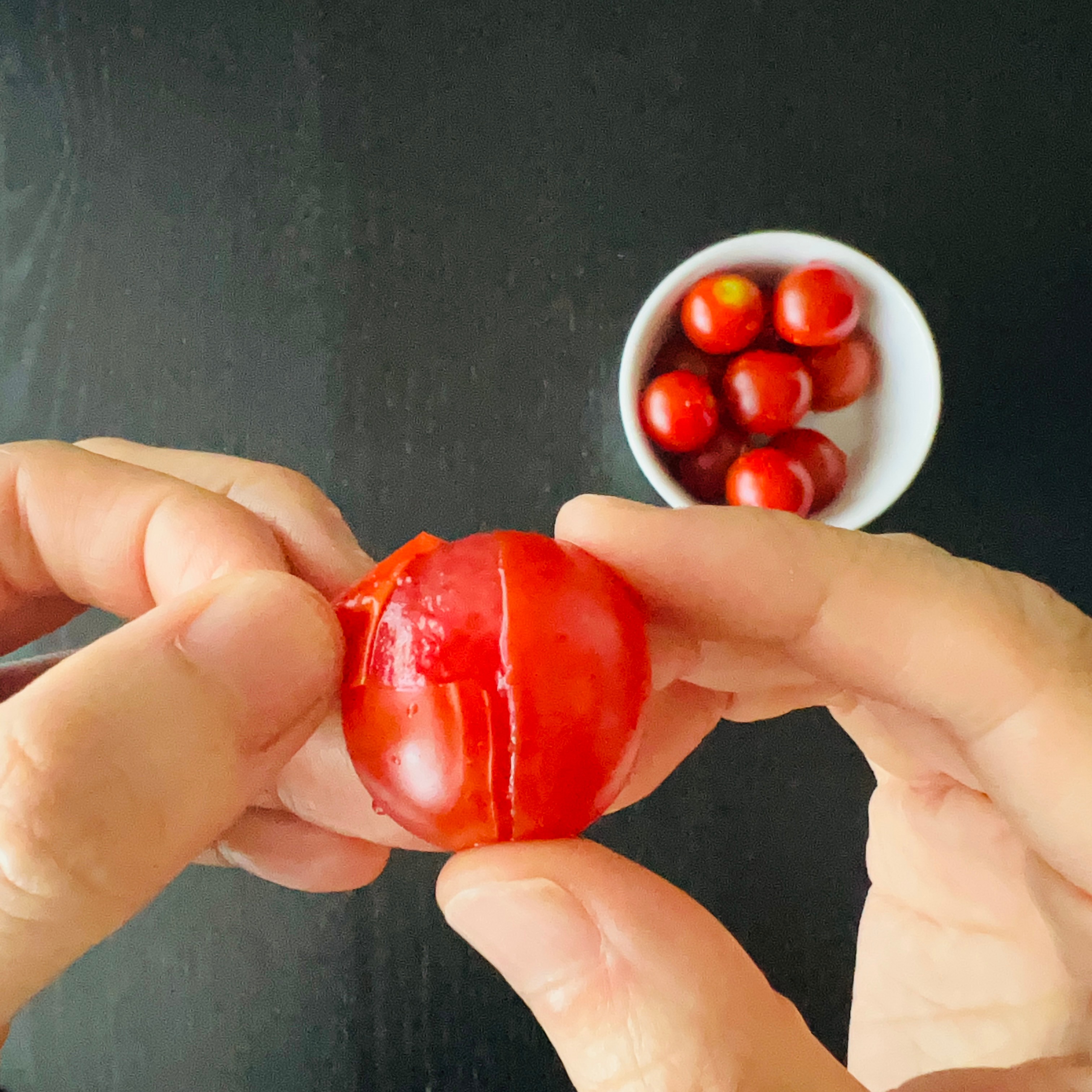 Peeling the skin off of the cherry tomatoes