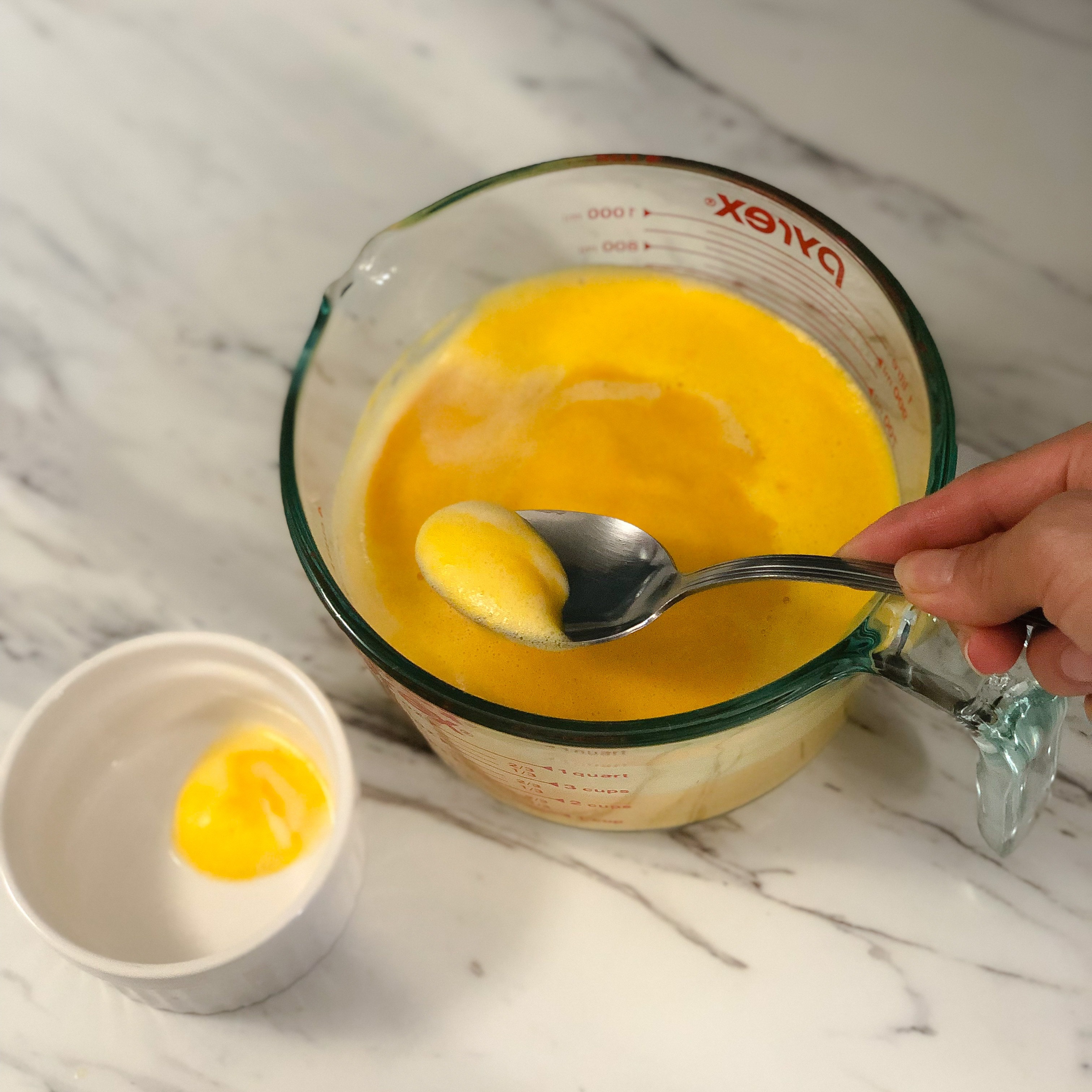 Spooning off any foam from the kabocha mixture