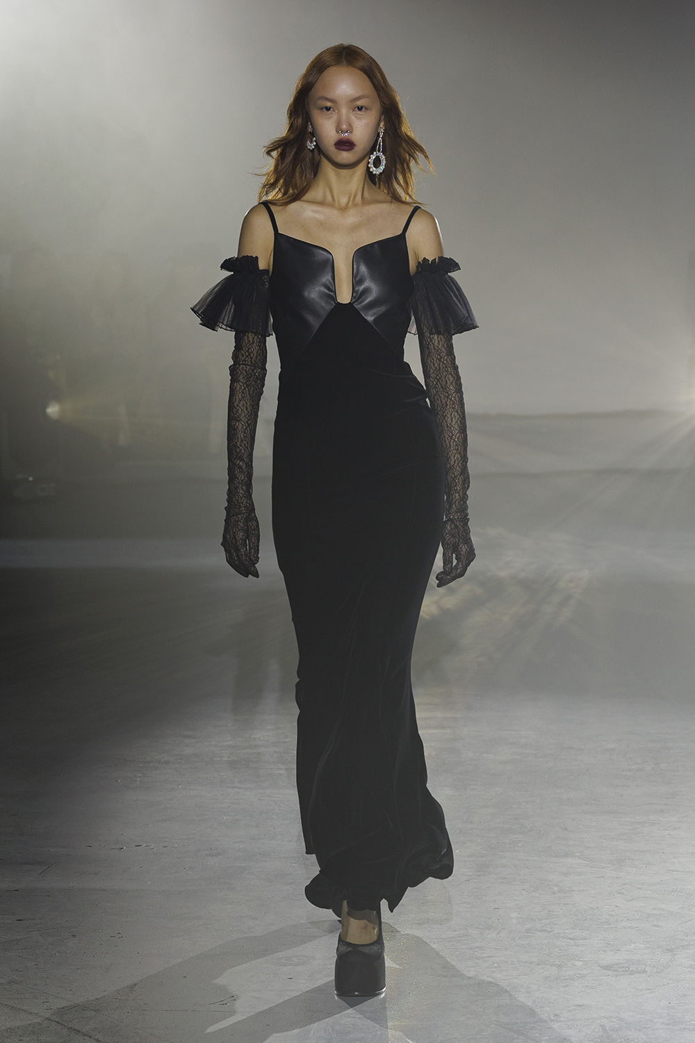 Model wears a black long dress with black gloves