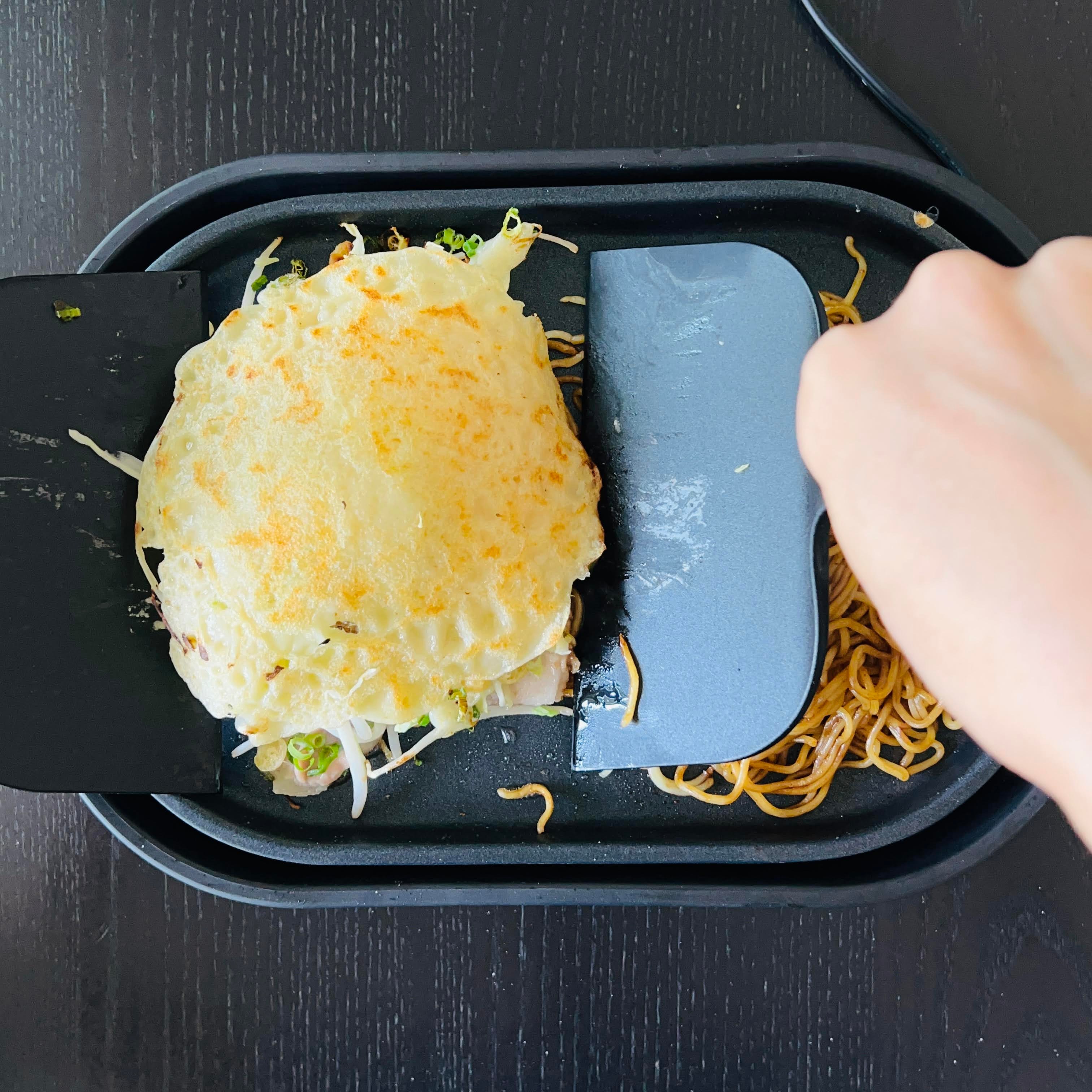 Putting the okonomiyaki on top of the noodles
